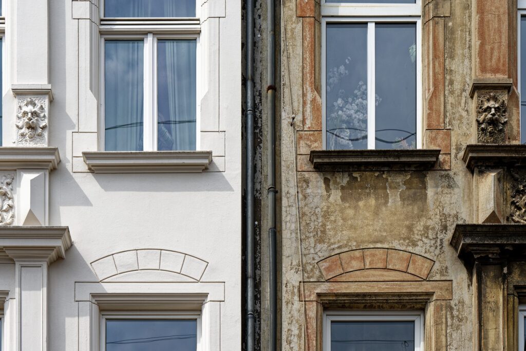 Die Fassade eines Hauses ist zu sehen. Das linke wurde energetisch saniert. Das Rechte ist noch im alten Zustand.