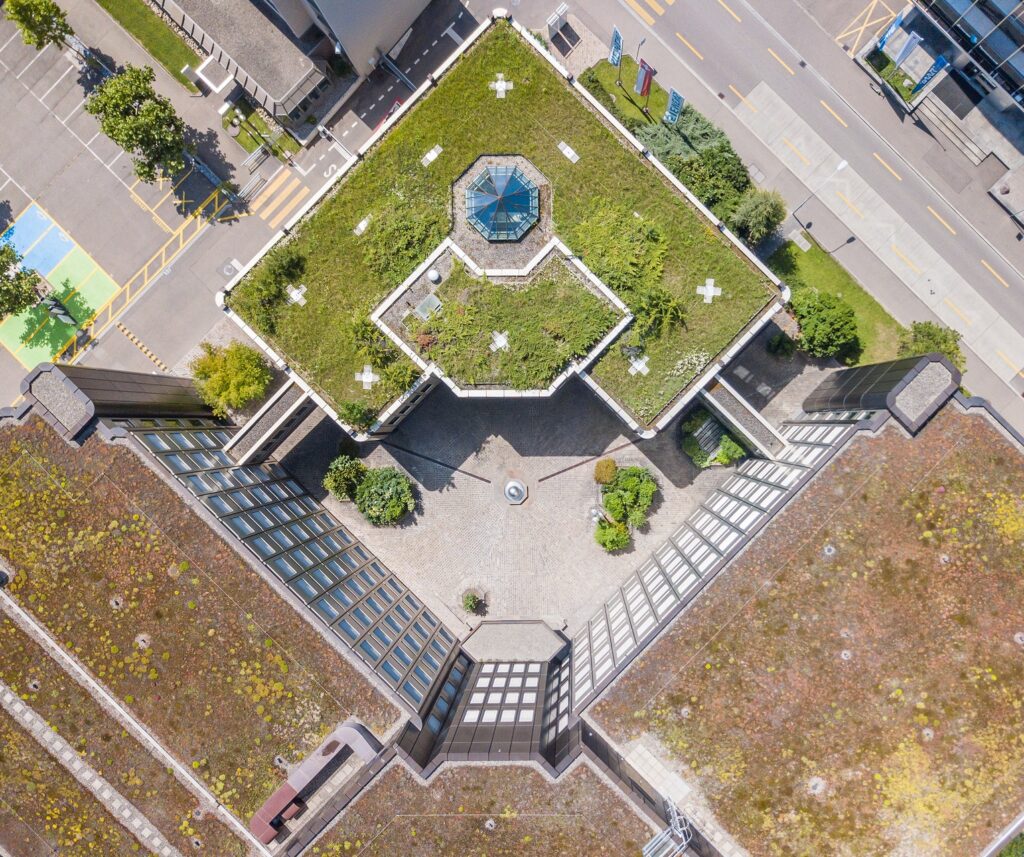 Drohnenaufnahme eines Gebäudes mit einer begrünten Dachfläche.