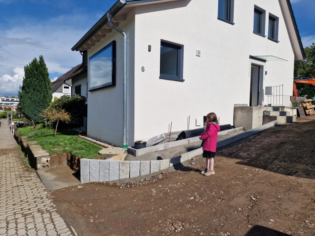 Haus Durchblick von der Seite. Weiße Fassade, großes Fenster.