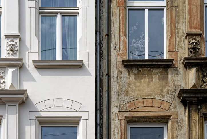 Die Fassade eines Hauses ist zu sehen. Das linke wurde energetisch saniert. Das Rechte ist noch im alten Zustand.